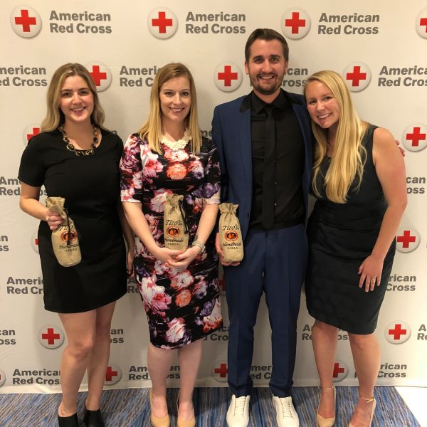 Image of four people holding bottles of Titos Vodka at an American Red Cross Event.