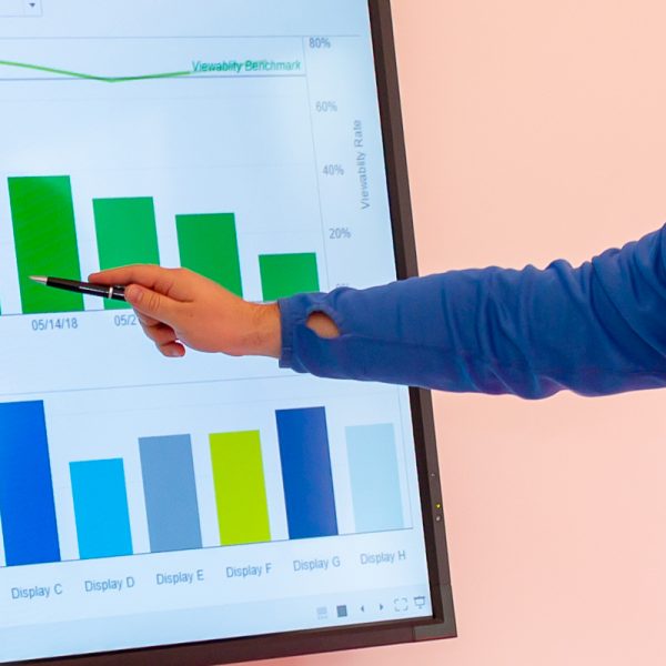 Image of a man pointing a pen at a bar chart.