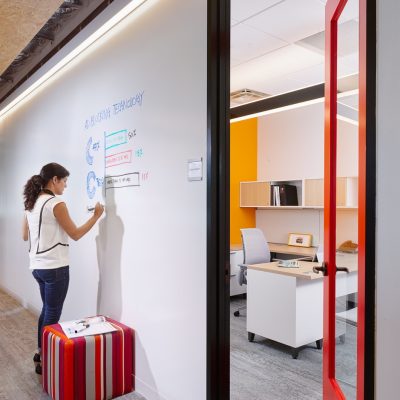 Image of a woman writing on a dry erase board.