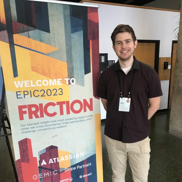 KSM Planner & Strategist Joshua Parrack, standing next to an EPIC People Conference 2023 banner